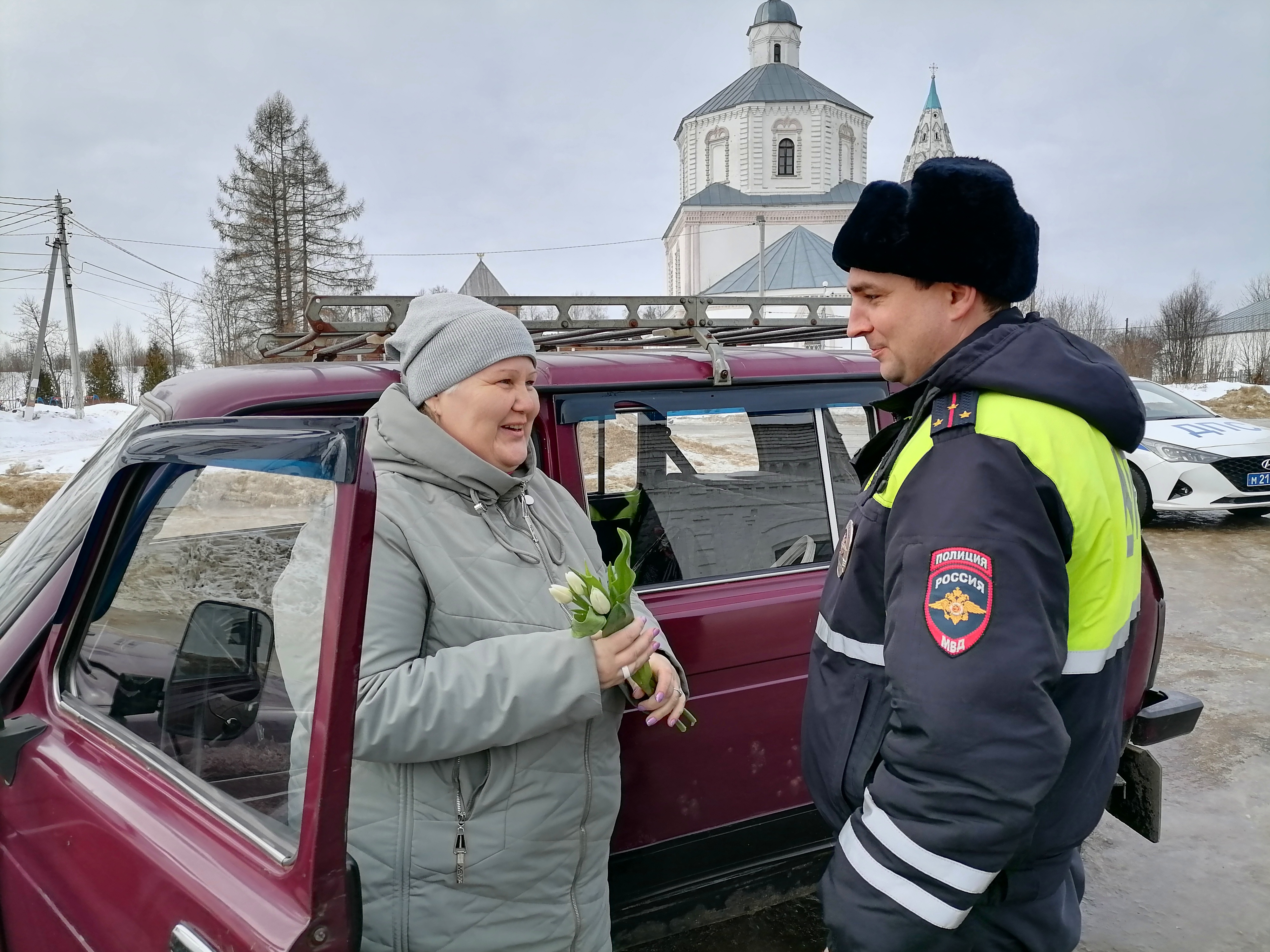 Представительницам прекрасного пола за рулем вручали главный символ весны - цветы.